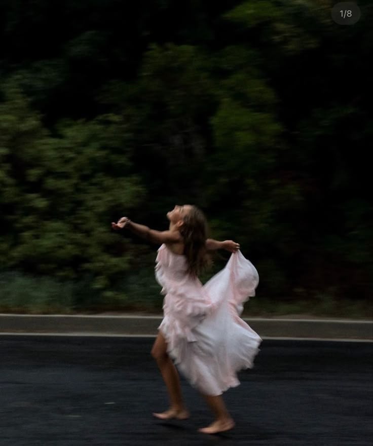 Woman dancing freely in a flowing dress, expressing physical and emotional release